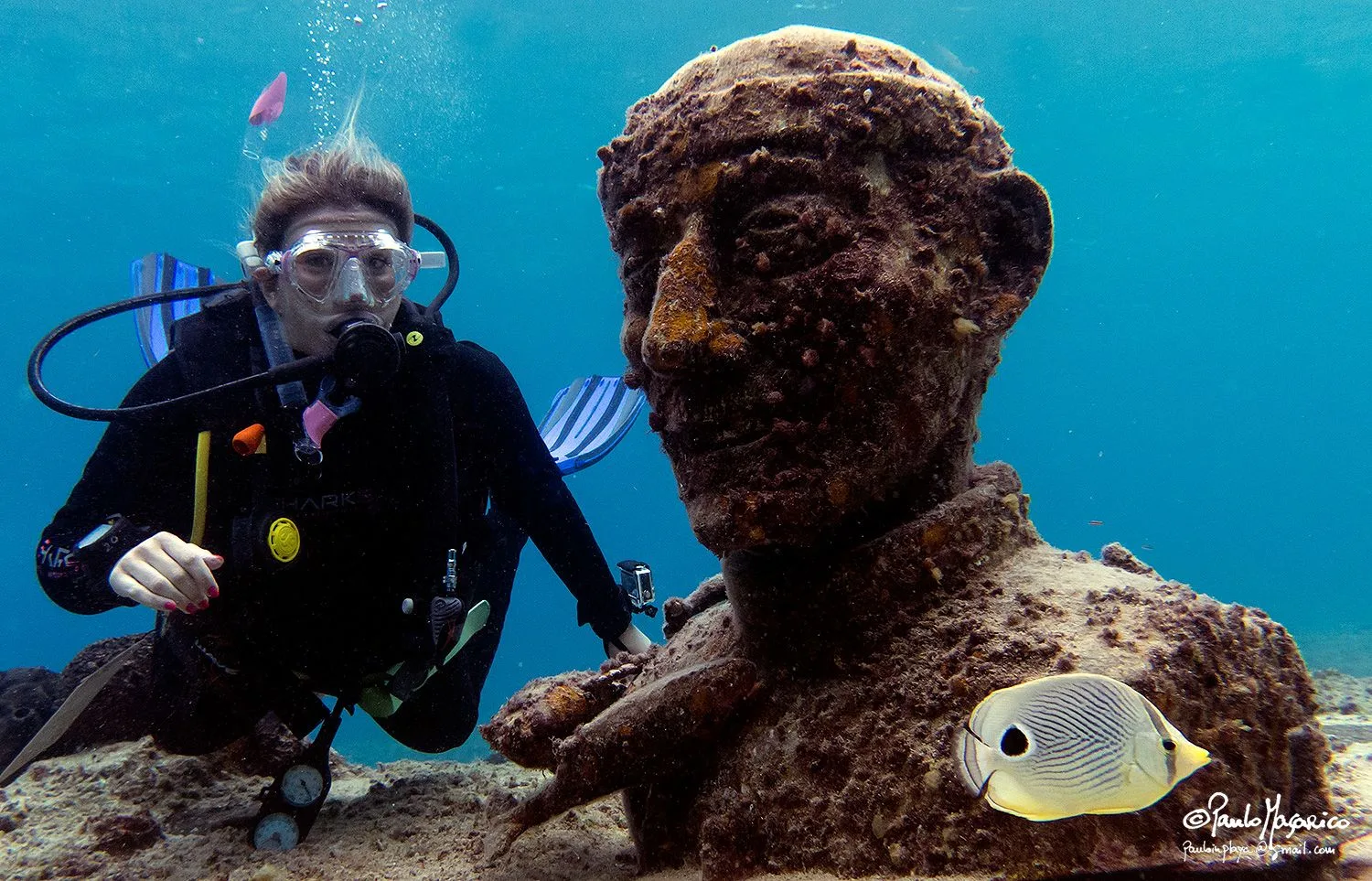 A diver next to Cousteau's statue in Cozumel
