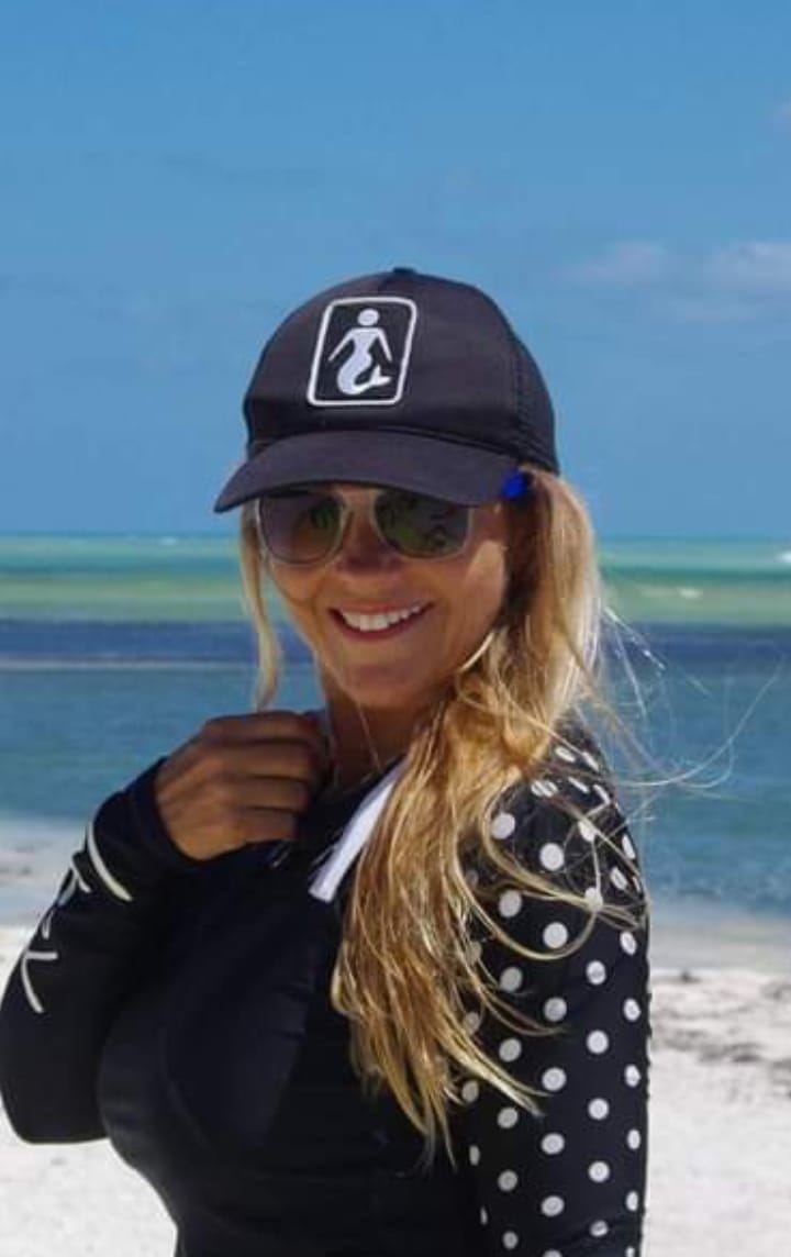Gigi smiling on a beach
