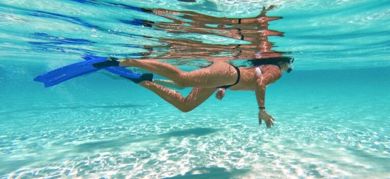 Person snorkeling in clear turquoise water